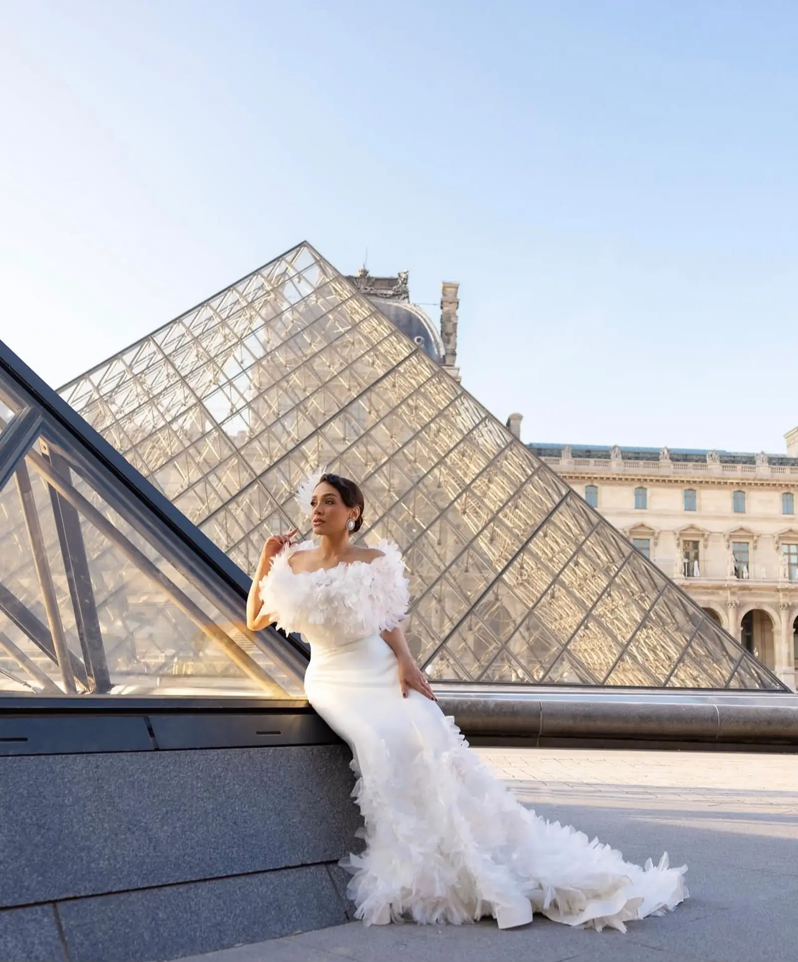 Noiva com vestido bordado floral em frente à pirâmide do Louvre, Paris
